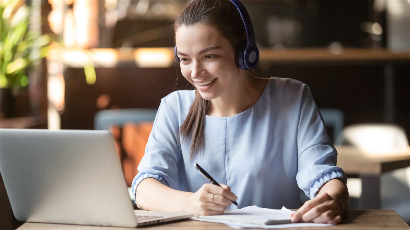 Peserta belajar melalui laptop sambil mencatat dan memakai headset