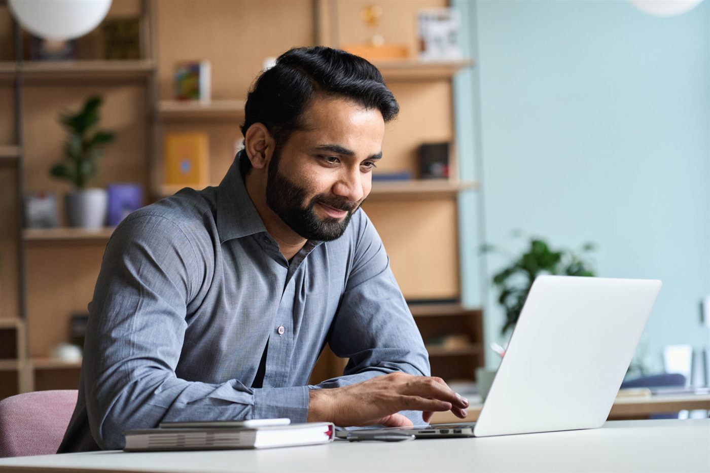 Seorang profesional menggunakan laptop di meja kerja